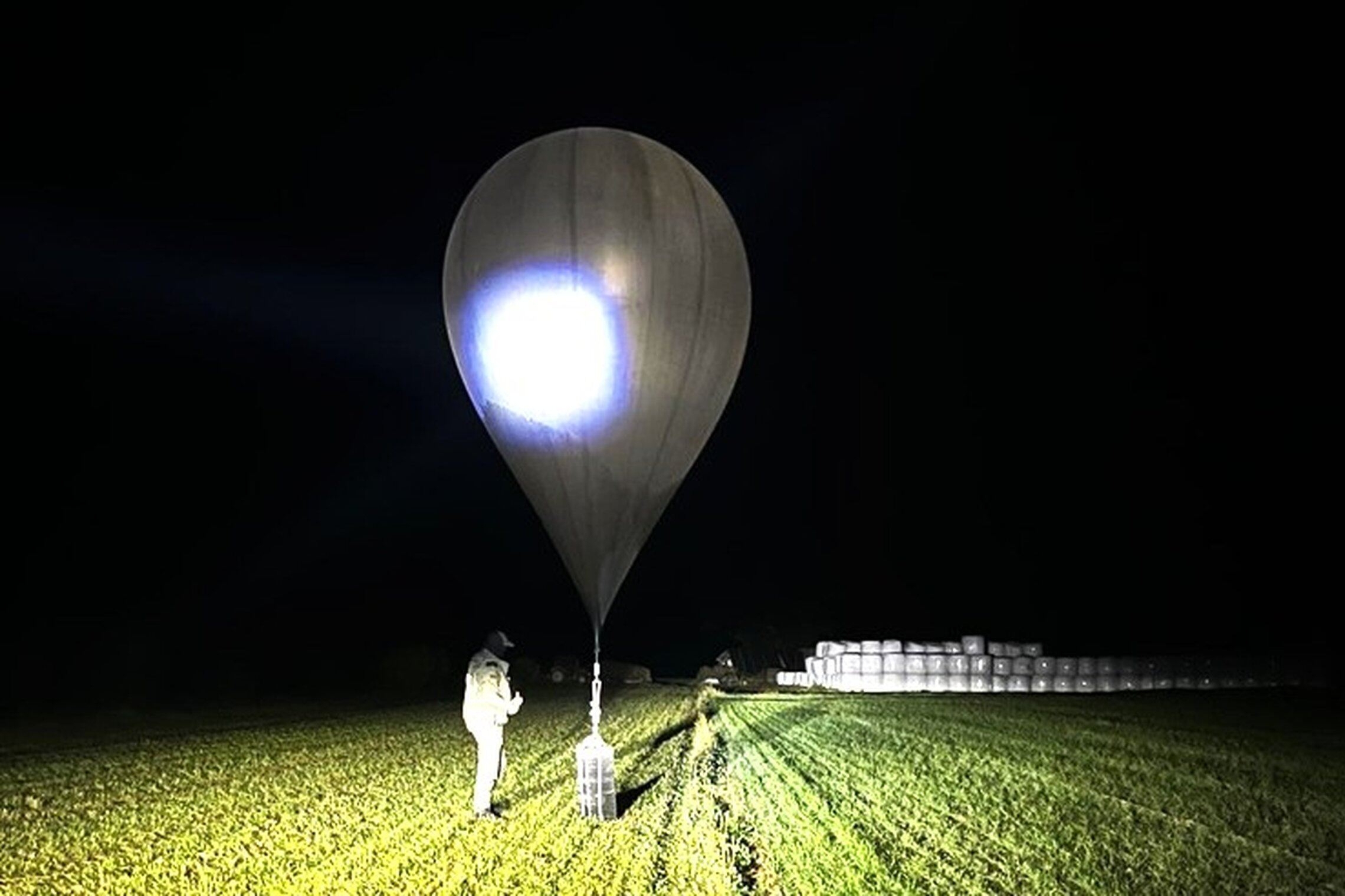 FILE - In this undated photo released by the State Border Guard Service, an officer inspects a balloon used to carry cigarettes into Lithuania, because Belarussian smugglers often use them to ferry the contraband into the European Union.